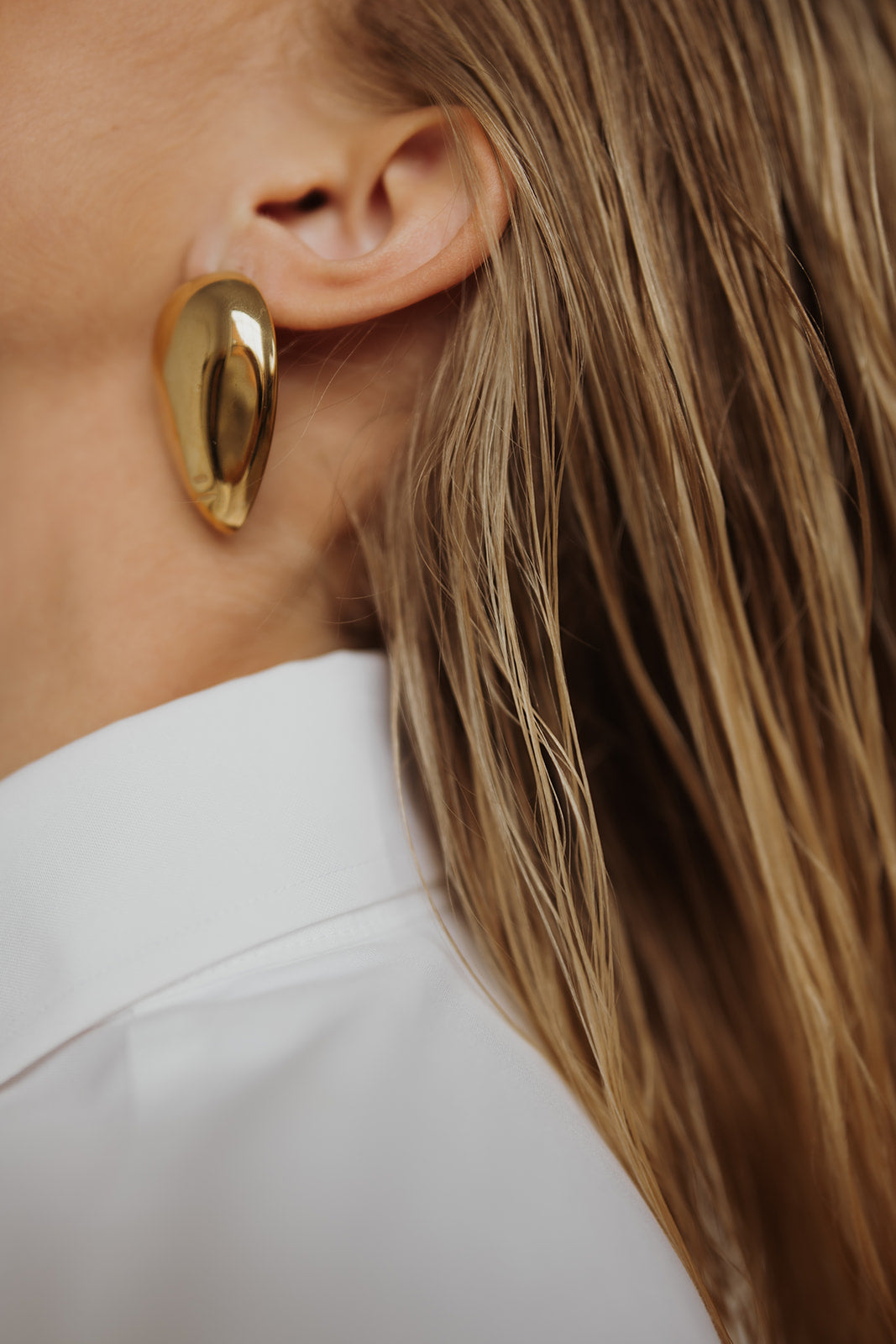 Close-up of a gold earring worn by a person with blonde hair walnut creek ca Hair extensions Walnut Creek CA